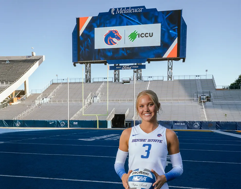Lilli Etter of Boise State Volleyball in front of Jumbotron featuring Broncos and ICCU logos