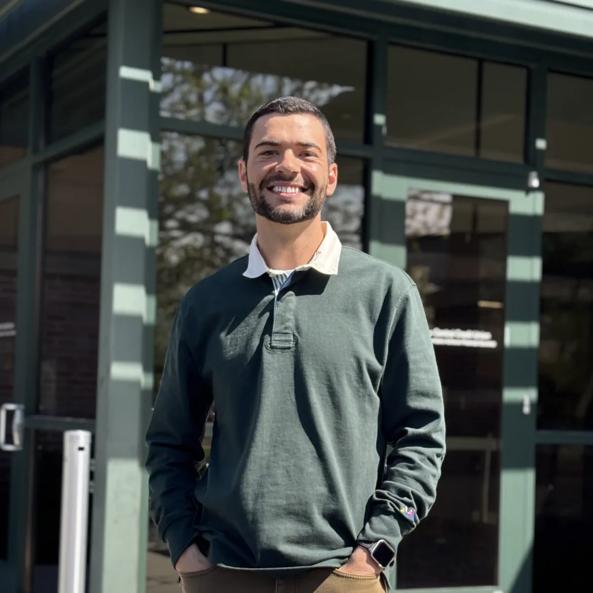 Darian smiles at the camera outside of Pierce Park branch, where he teaches high school students about financial literacy in real time.