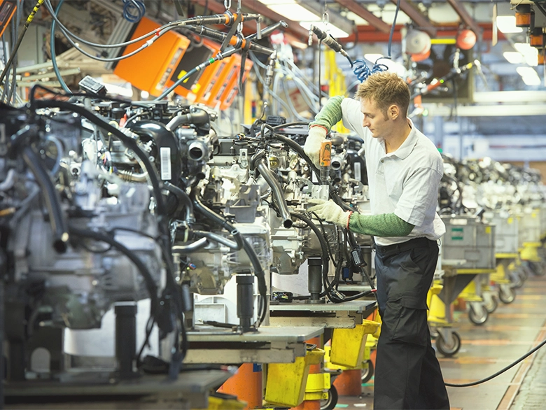 A man working on engines in a car production factory